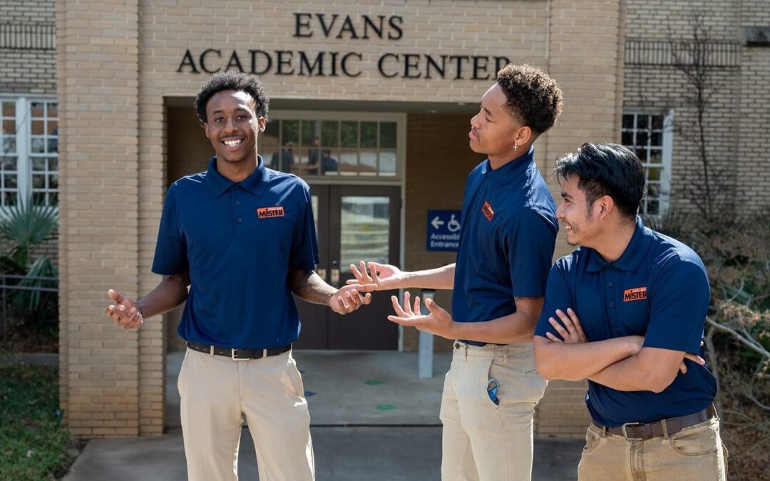 Aspiring teachers in the Call me Mister program stand outside of the new Evans building.