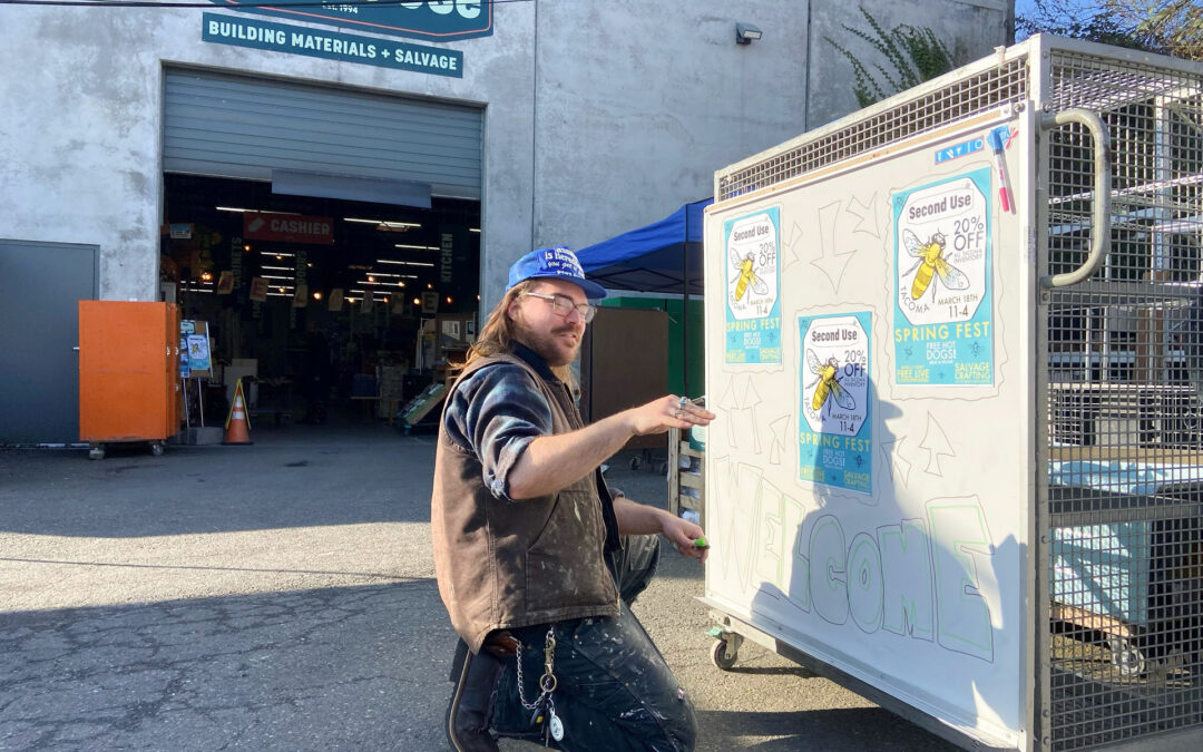 A creative Second Use staff member enhancing signage for their Spring Fest